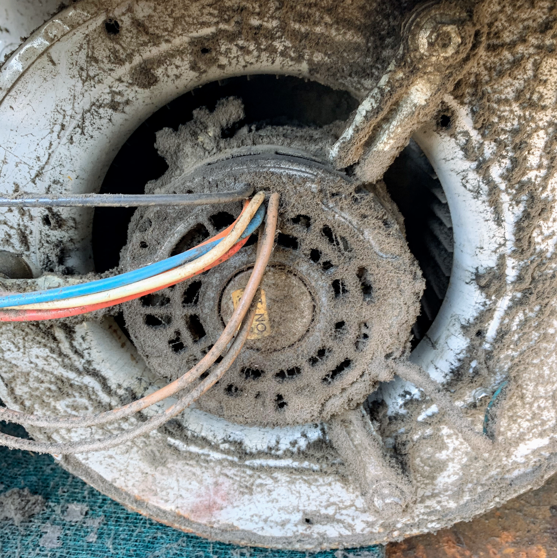 Dust-covered HVAC motor with wires.