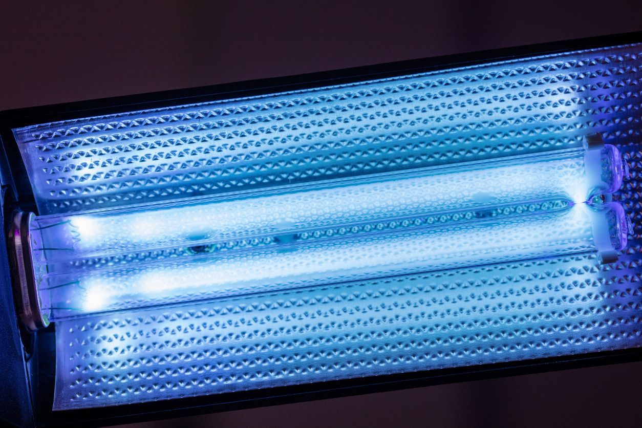 White ceiling with air vents and surgical lights in an operating room.