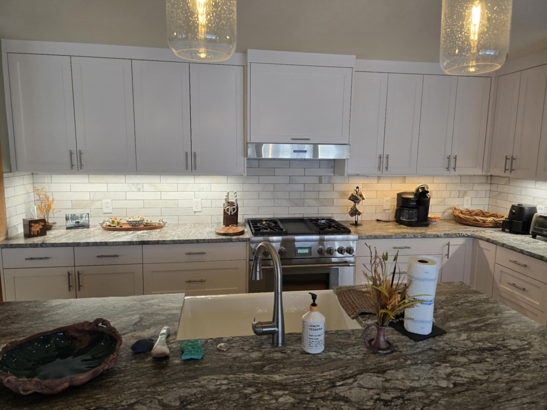 Kitchen with white cabinets, granite countertops, and stainless steel appliances.