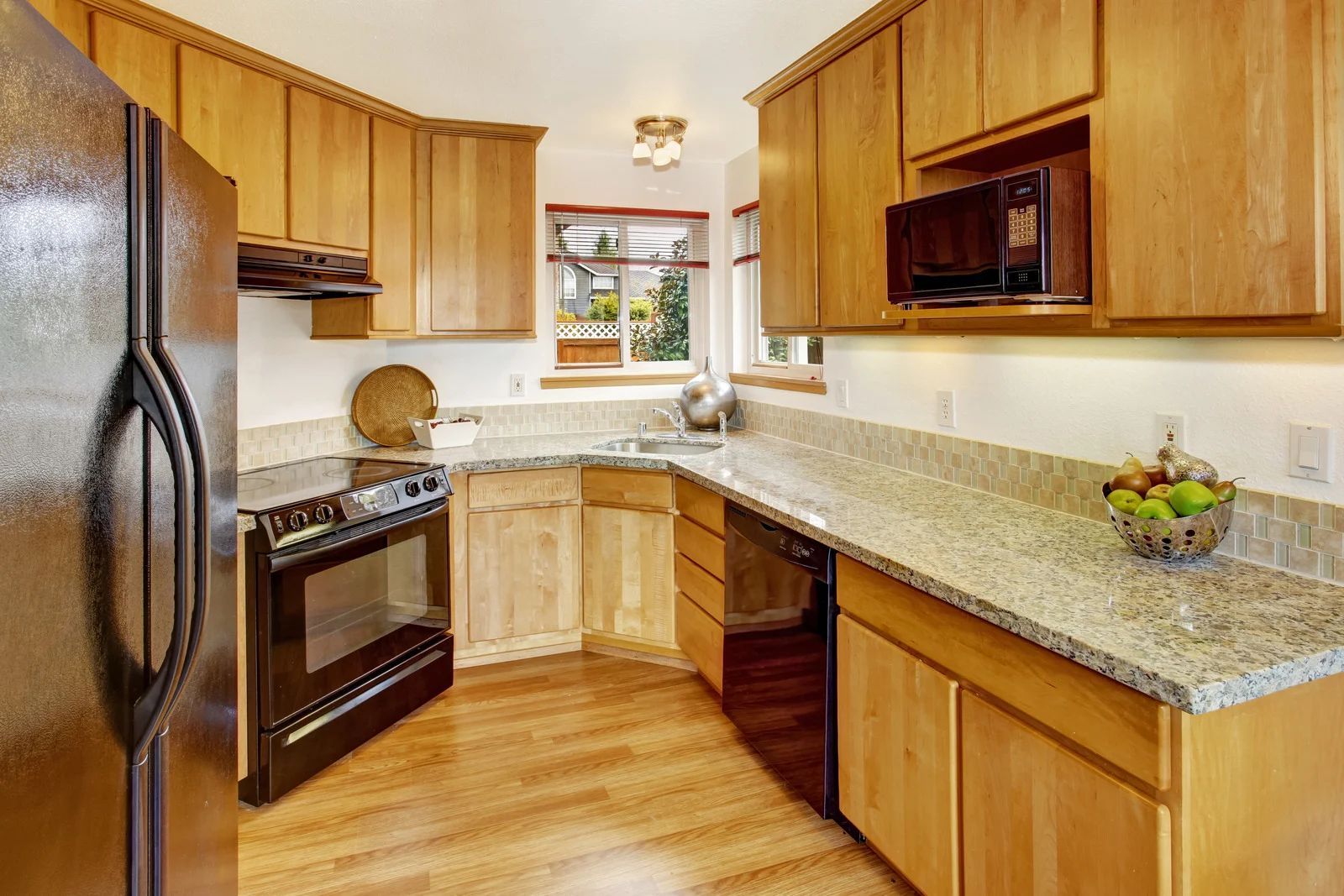 Modern kitchen with gray and white cabinets, wood countertop, built-in appliances, and recessed lighting.