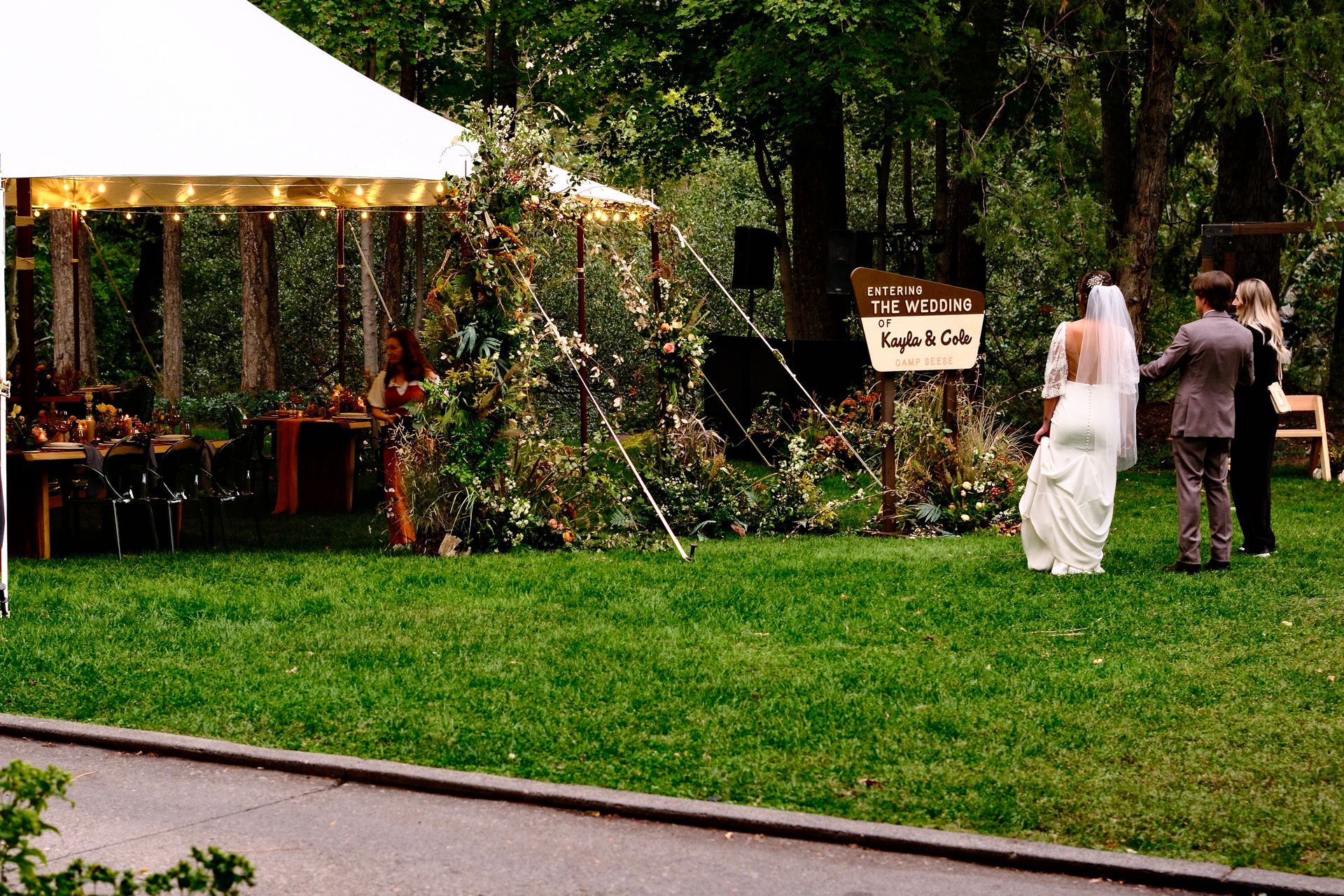 Bride and groom standing on a decorated lawn at an outdoor wedding reception