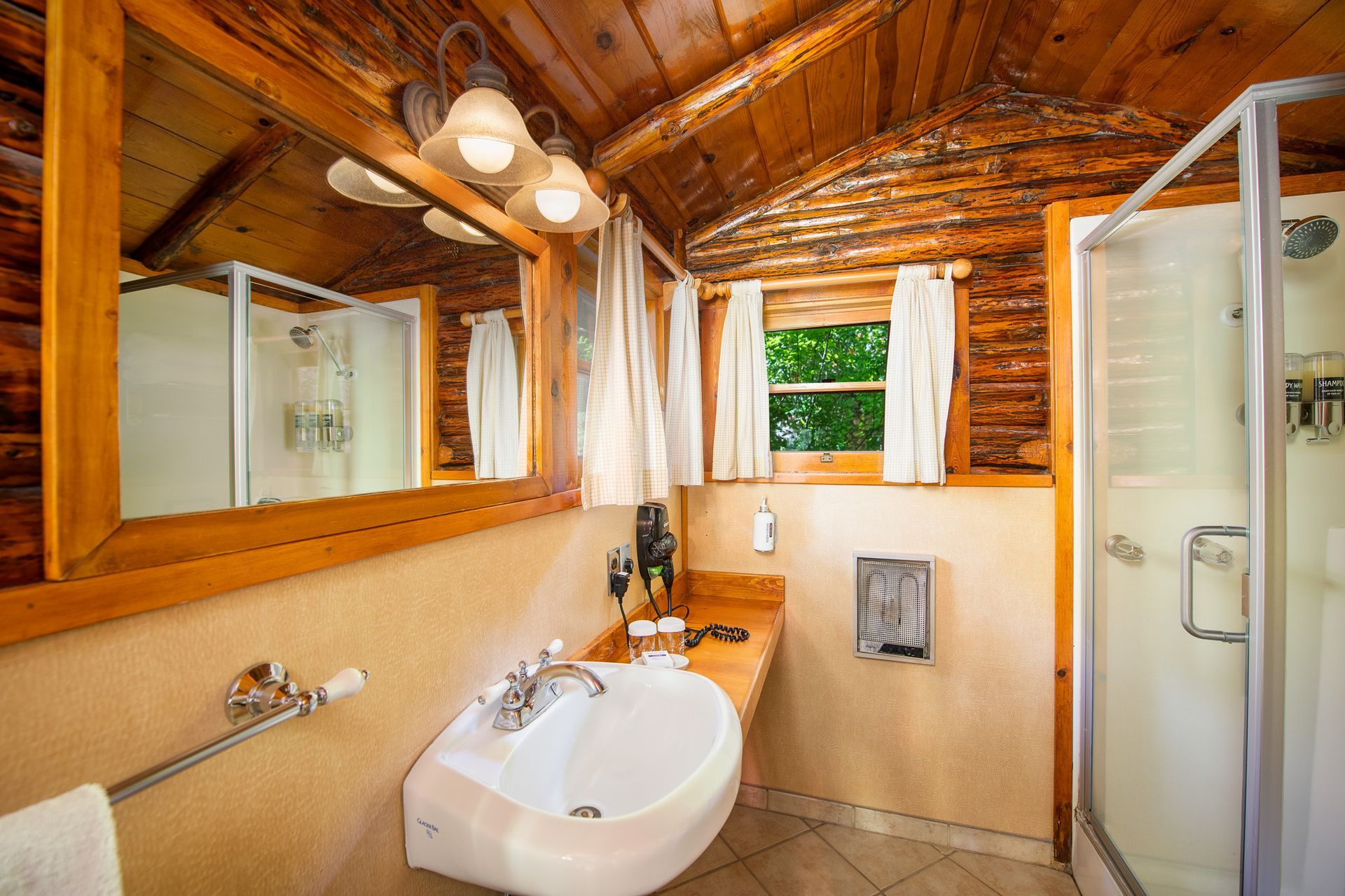 Rustic bathroom with wood ceiling, sink, mirror, and glass shower stall
