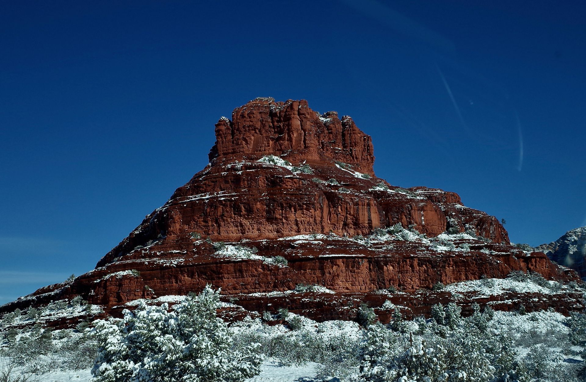 Red rock mesa capped with snow under a clear blue sky