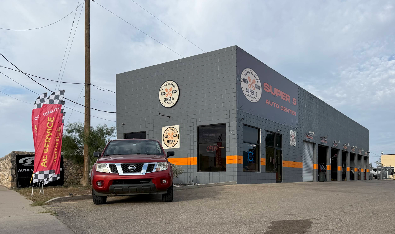 Gray auto repair shop with orange accents and a red SUV parked outside on an overcast day | Super 5 Auto Center