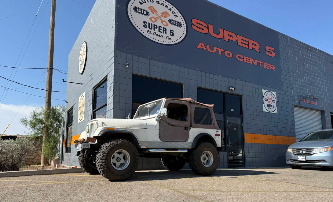 White Hummer parked outside Super 5 Auto Center on a sunny street, with a silver car beside it | Super 5 Auto Center