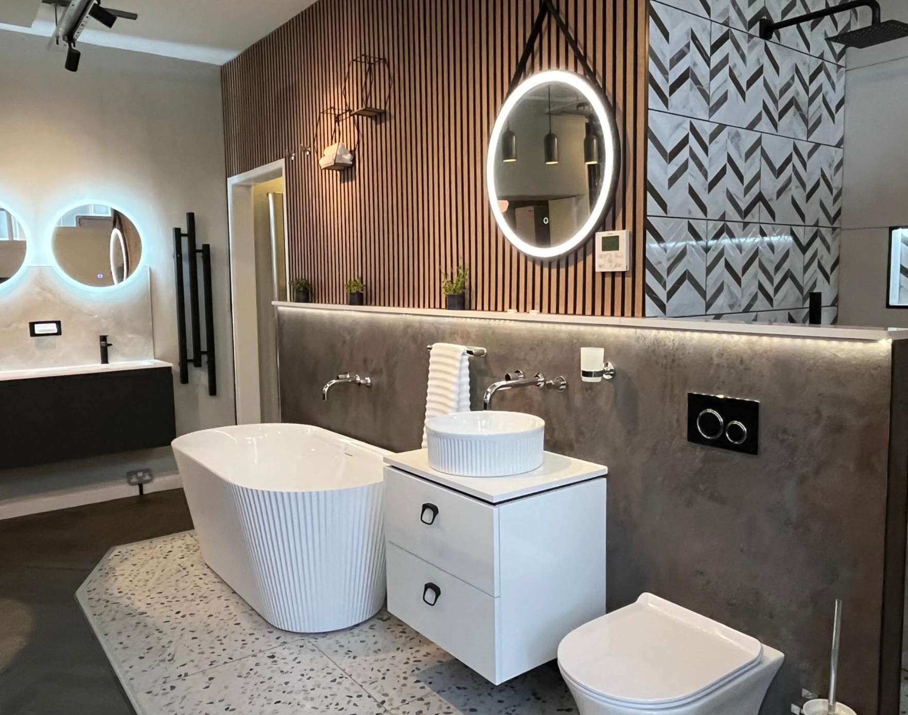 Modern bathroom with freestanding tub, double vanity, round mirrors, and wood-accent walls