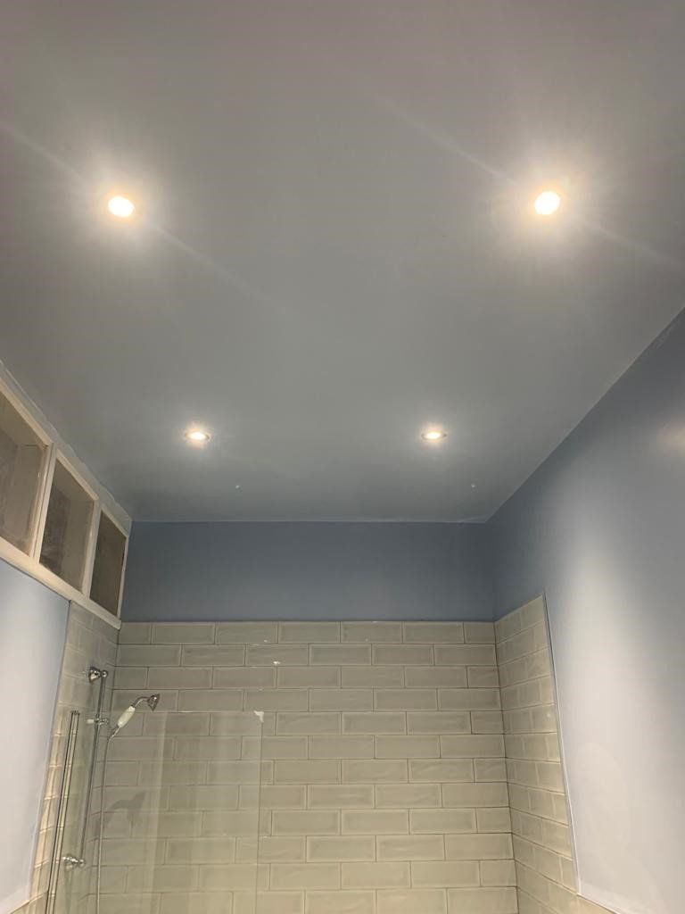 Bathroom with blue ceiling, white subway tile shower, and recessed lights.
