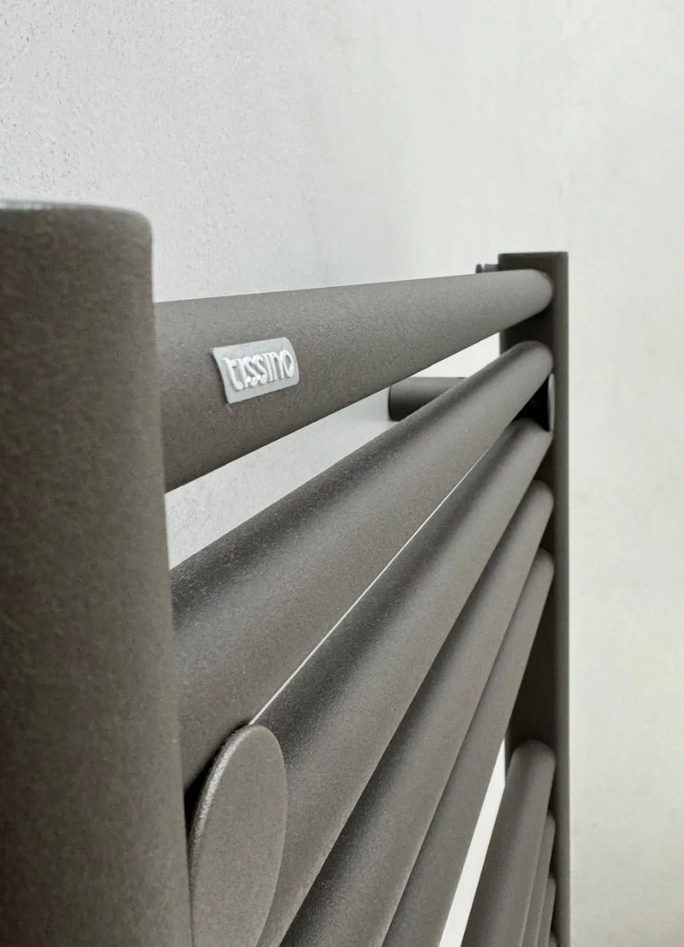 Gray metal railing with horizontal bars against a white wall