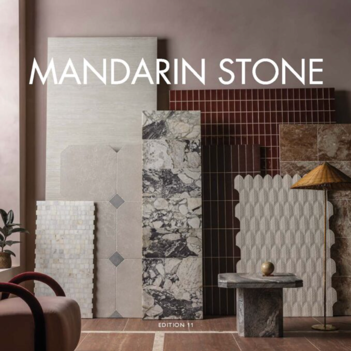 Mandarin Stone showroom display of patterned tiles, stone slabs, and a small pedestal table in neutral tones