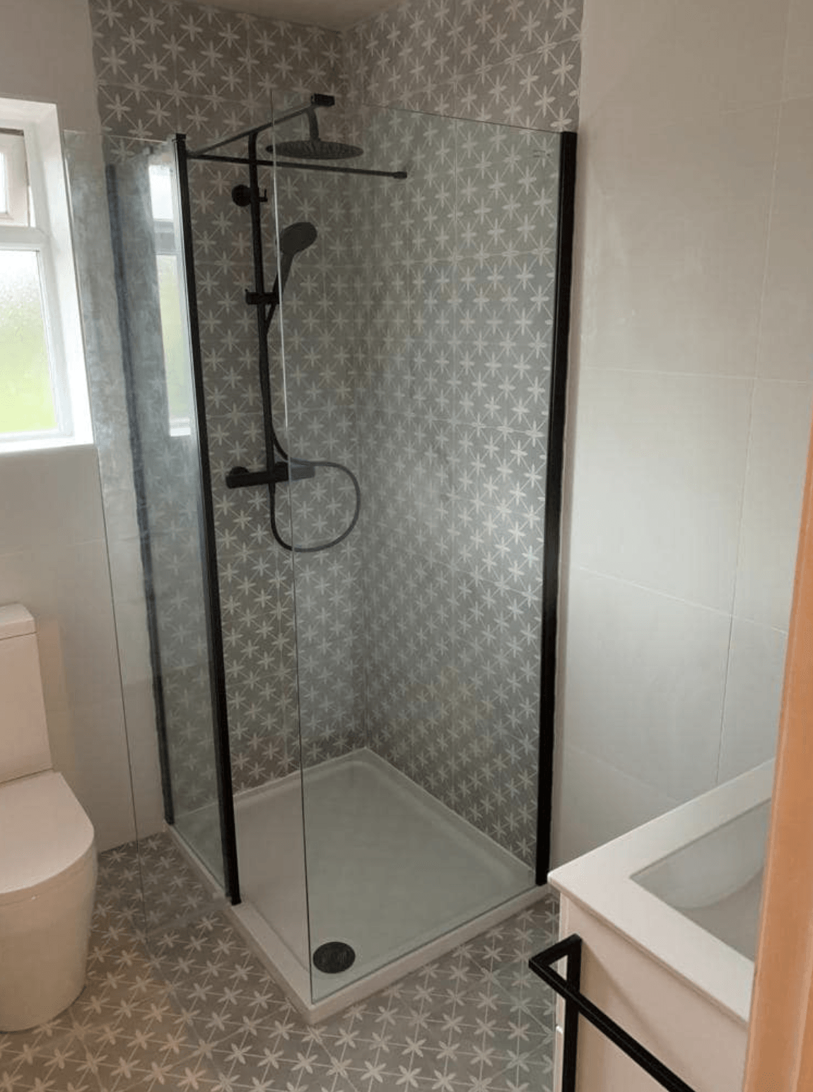 Modern bathroom with glass shower enclosure, toilet, and sink countertop