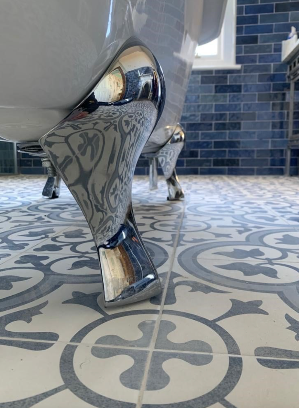 Chrome table leg on patterned tile floor in an outdoor patio area