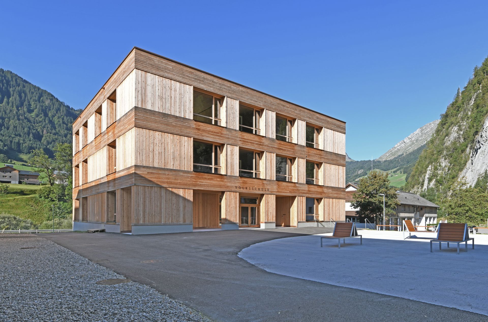 Ein großes Holzgebäude mit Bergen im Hintergrund