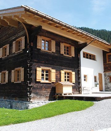 Ein großes Haus mit vielen Fenstern und Fensterläden