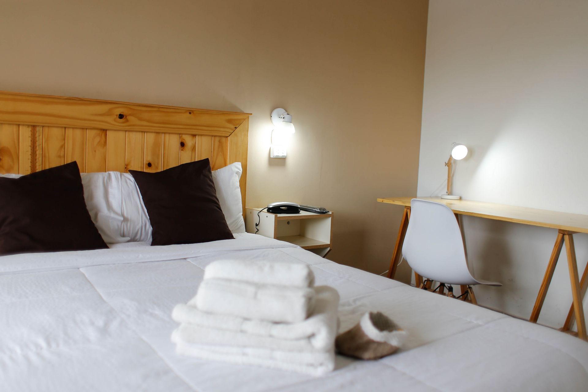 Un dormitorio con cama, escritorio y silla.