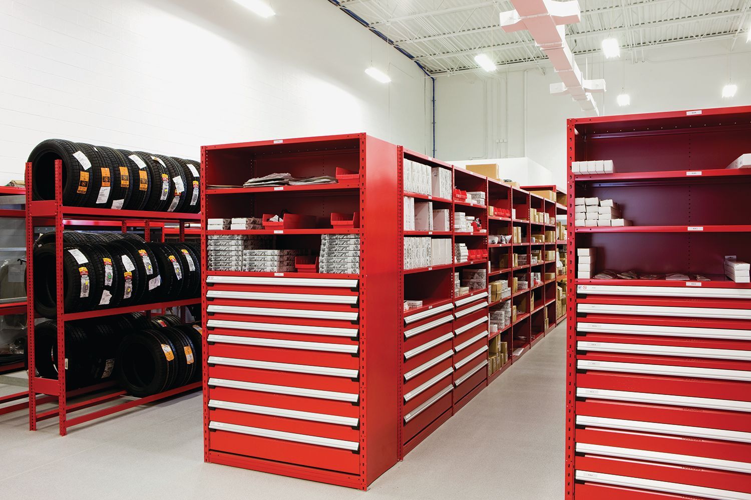 A warehouse filled with lots of red shelves and drawers