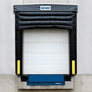 A blue giant dock shelter is attached to a warehouse door.