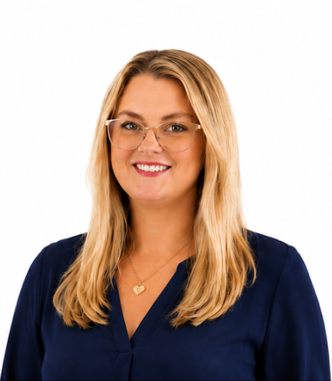 Ashley Portrait of a smiling woman with blonde hair, glasses, and a navy blouse on a white background