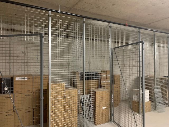 A warehouse filled with lots of boxes and a metal fence.