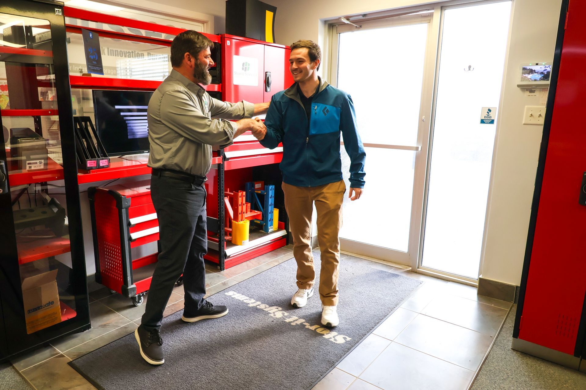 Two men are shaking hands in a garage.