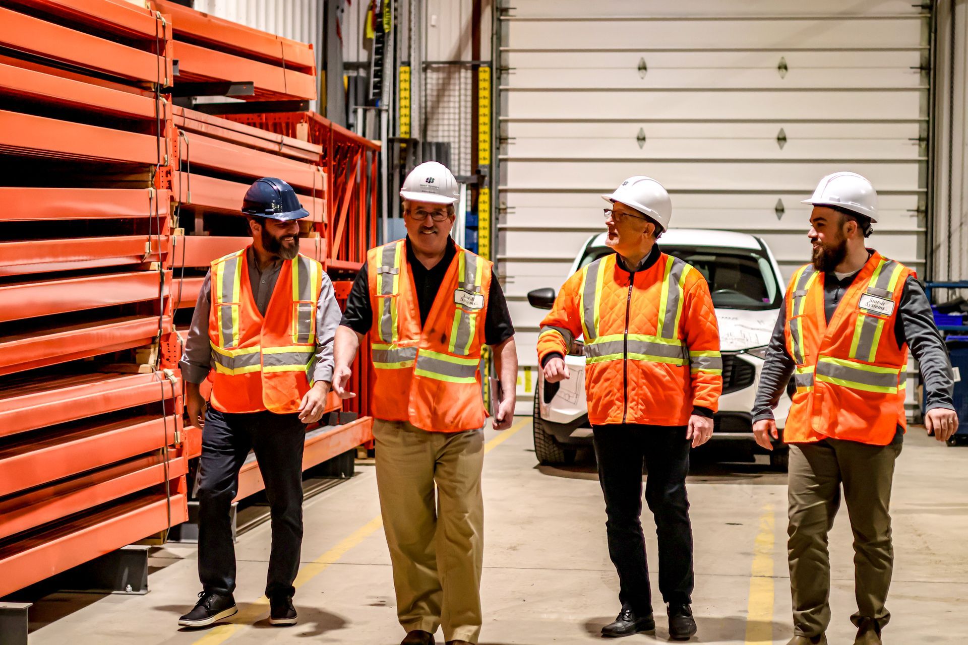 A group of construction workers are walking in a warehouse.