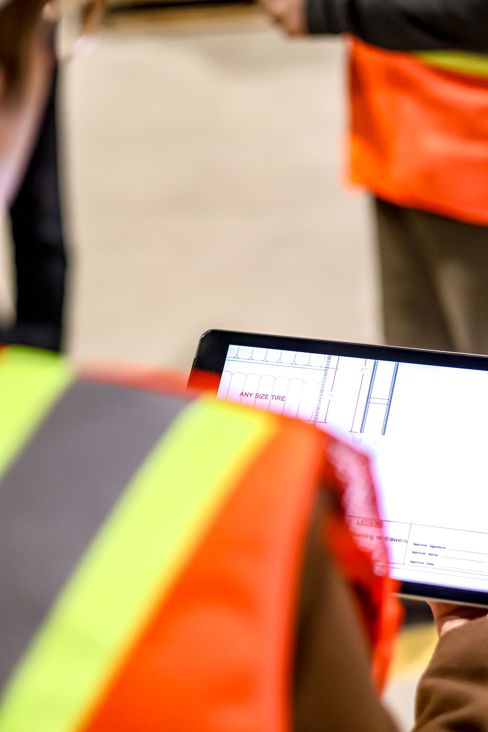A person wearing a safety vest is using a tablet