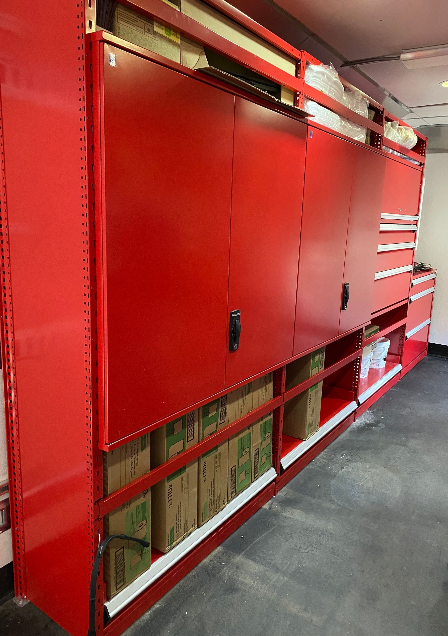 A row of red cabinets filled with boxes and tools