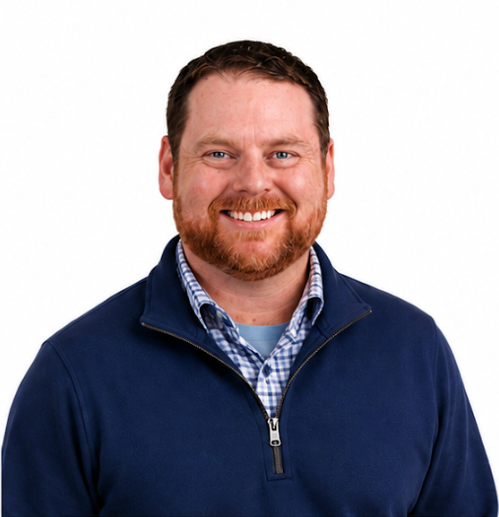 Jeremy Smiling man in a navy quarter-zip sweater over a blue plaid shirt on a white background