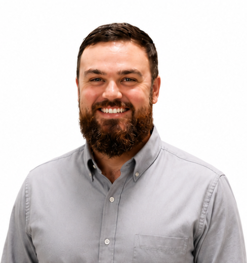 Mitch Smiling bearded man in a light gray button-up shirt against a white background