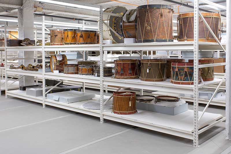 A warehouse filled with lots of drums on shelves.