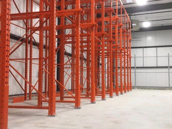A large warehouse with a lot of orange shelves