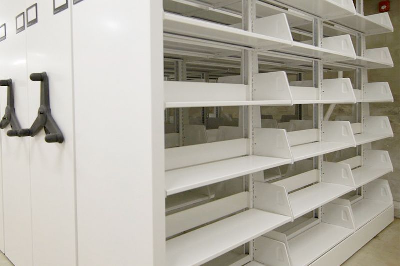 A row of white shelves in a library.