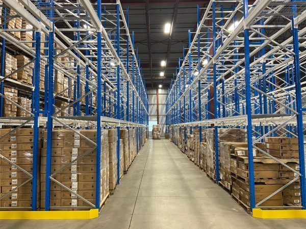 A large warehouse filled with lots of boxes on shelves.