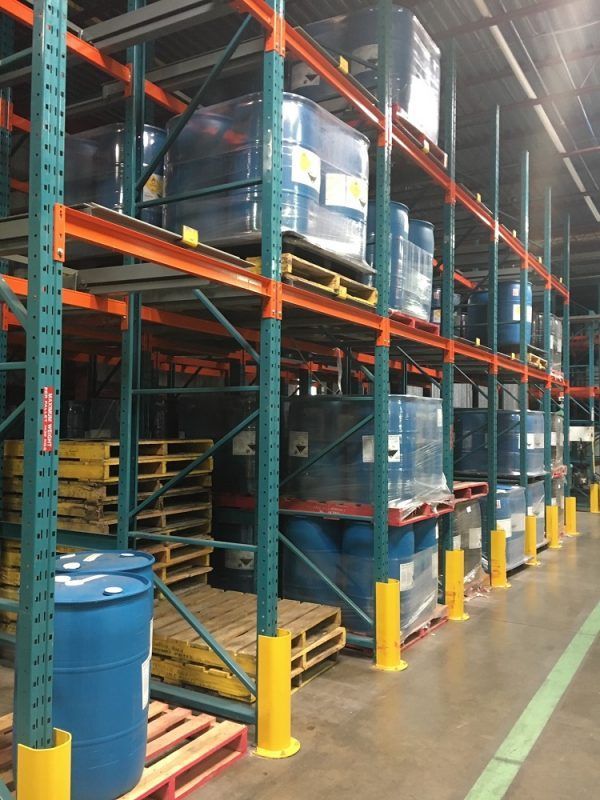A large warehouse filled with lots of barrels and pallets