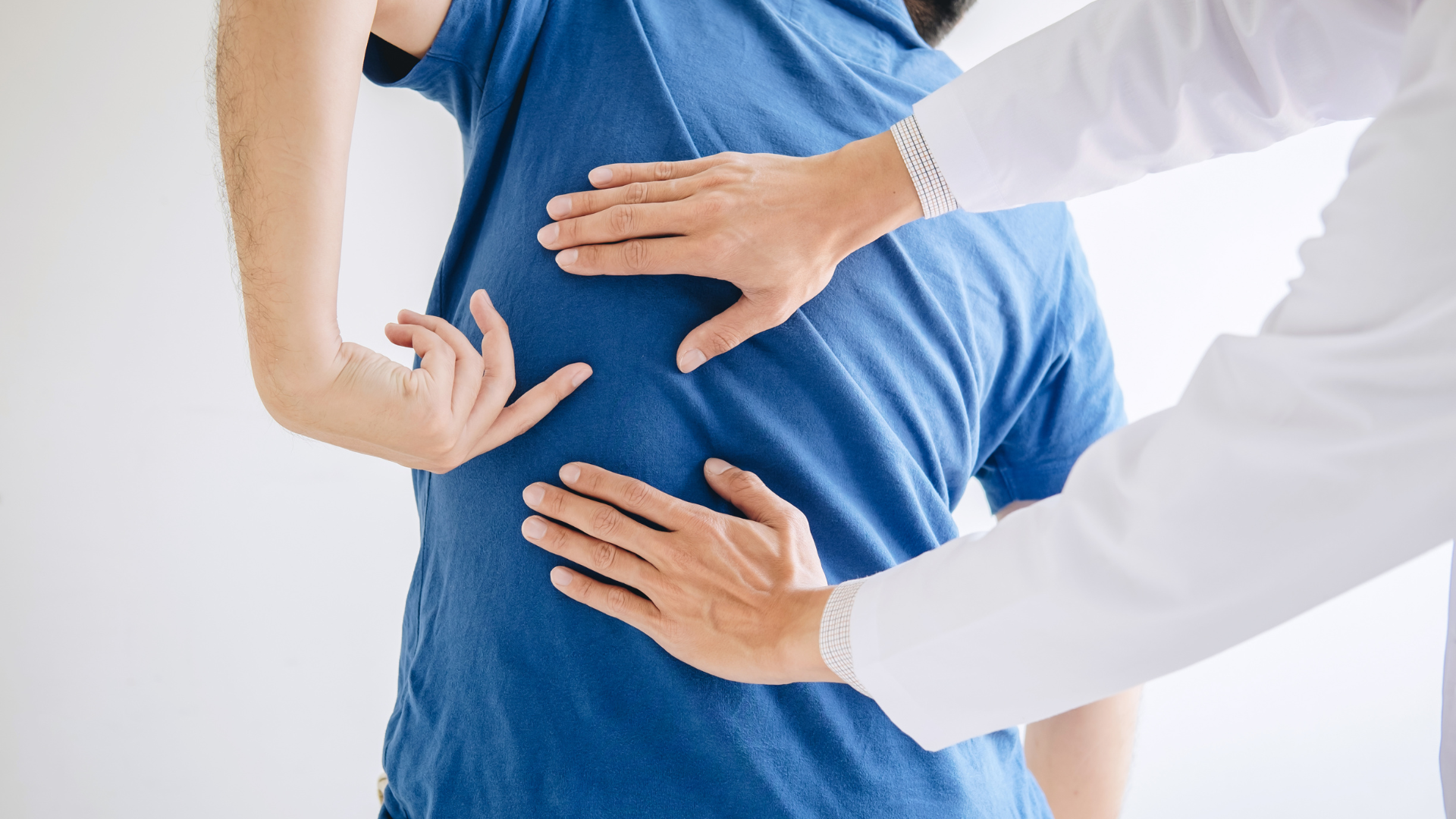 Doctor examining a person’s lower back pain against a white background