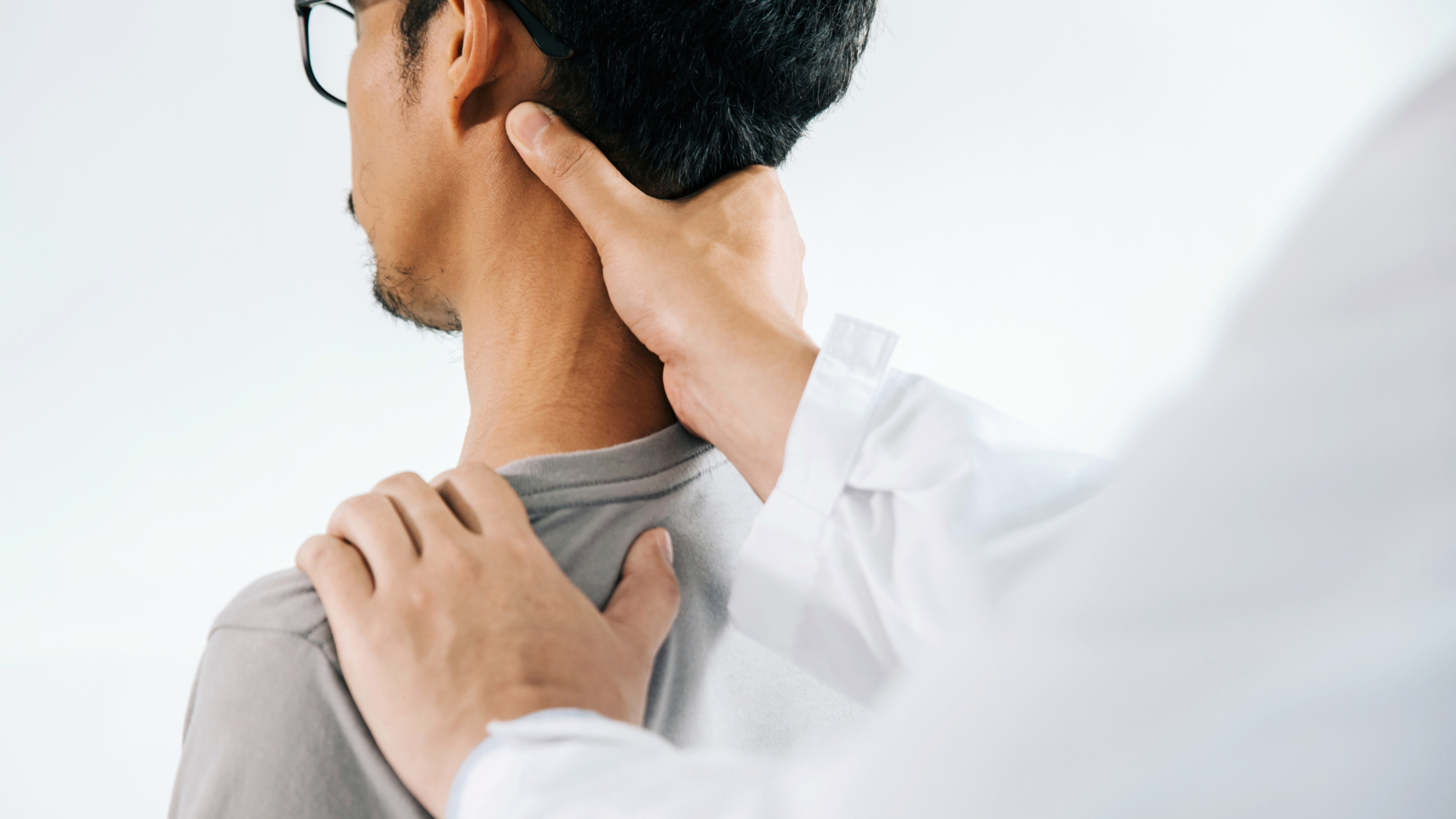 Person receiving a neck and shoulder massage in a bright clinical setting