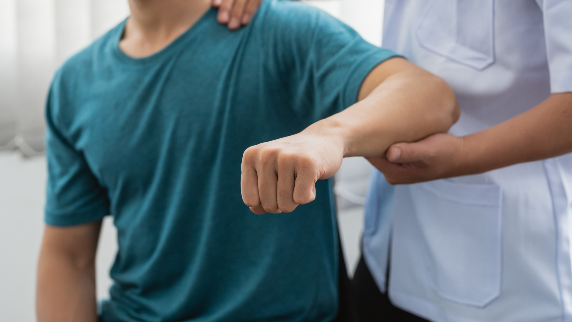 Physical therapist helping a patient extend his arm during rehabilitation assessment