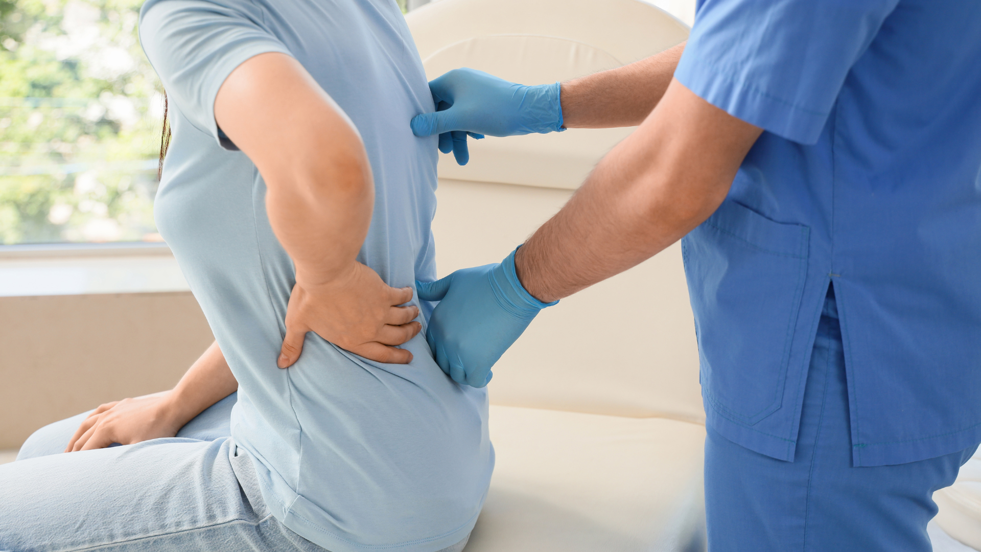 Physical therapist helping a patient stretch their back on a treatment table