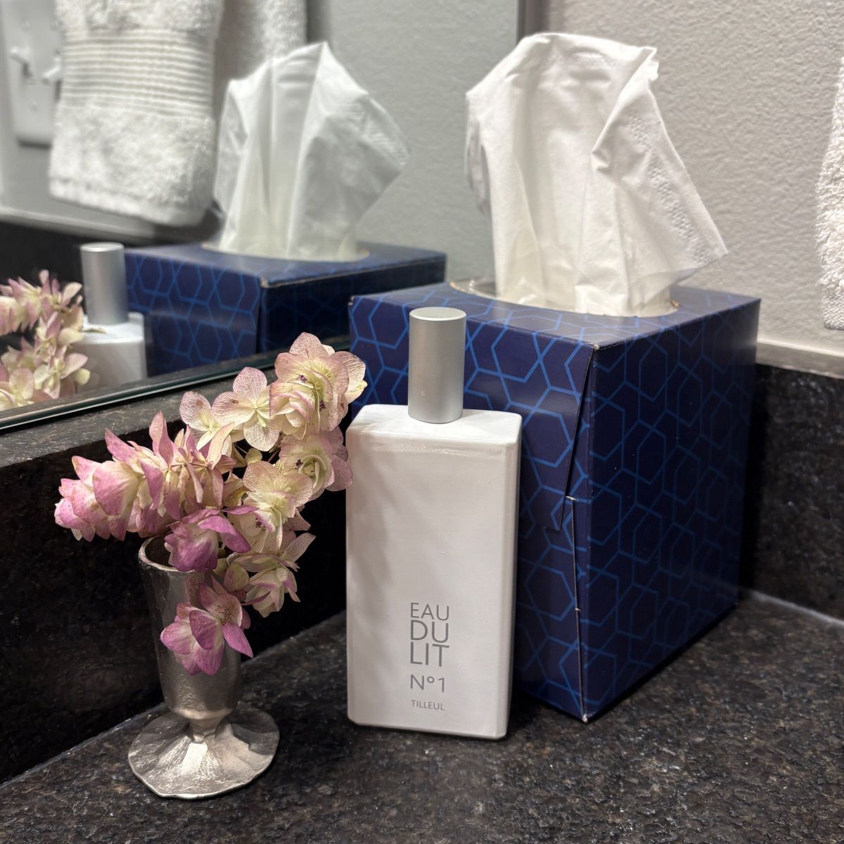 A bottle of eau de toilette sits on a bathroom counter