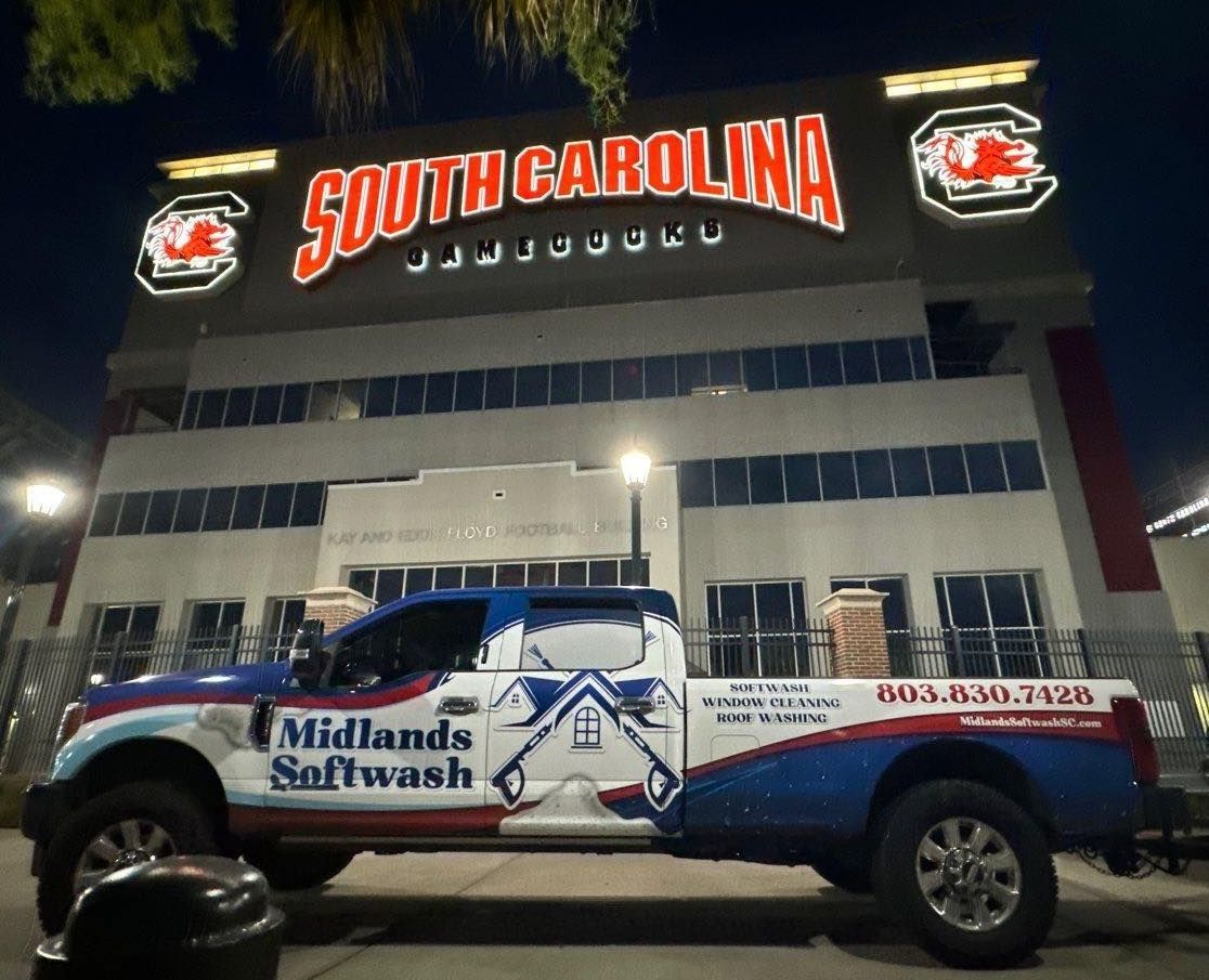 A south carolina soft wash truck is parked in front of a building