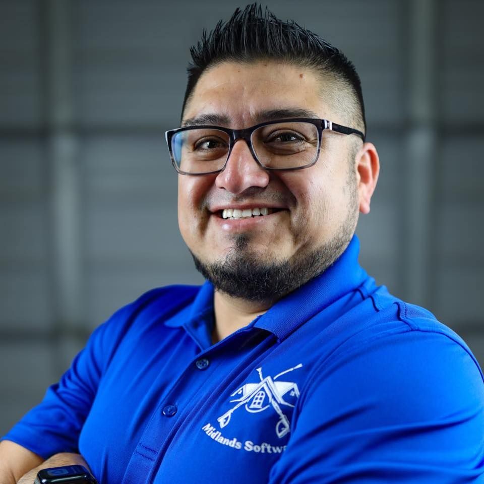 A man wearing glasses and a blue shirt with the word software on it