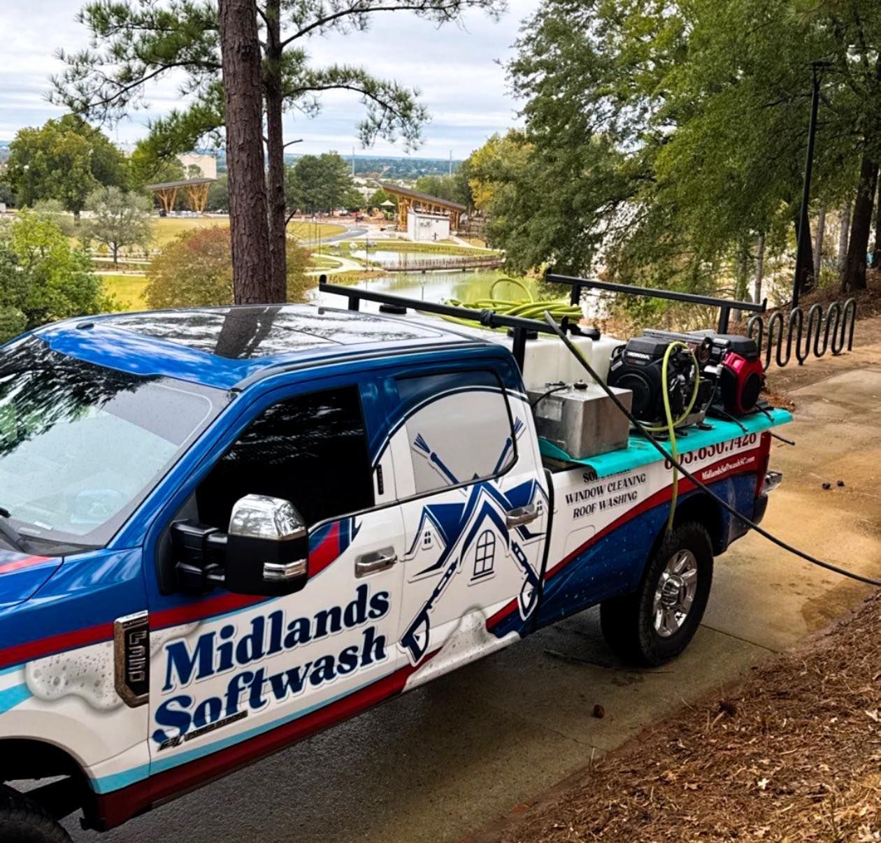 Blue and white Midlands Softwash utility truck parked on a dirt hill with cleaning equipment in back
