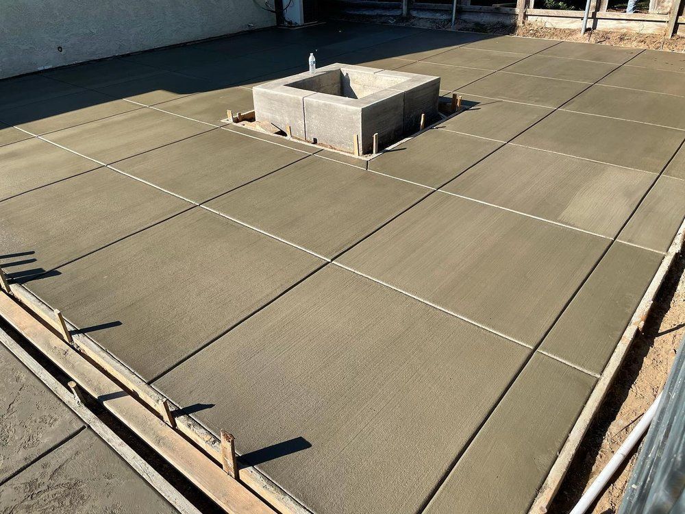 Rooftop with gray membrane panels and a central concrete vent structure in bright sunlight