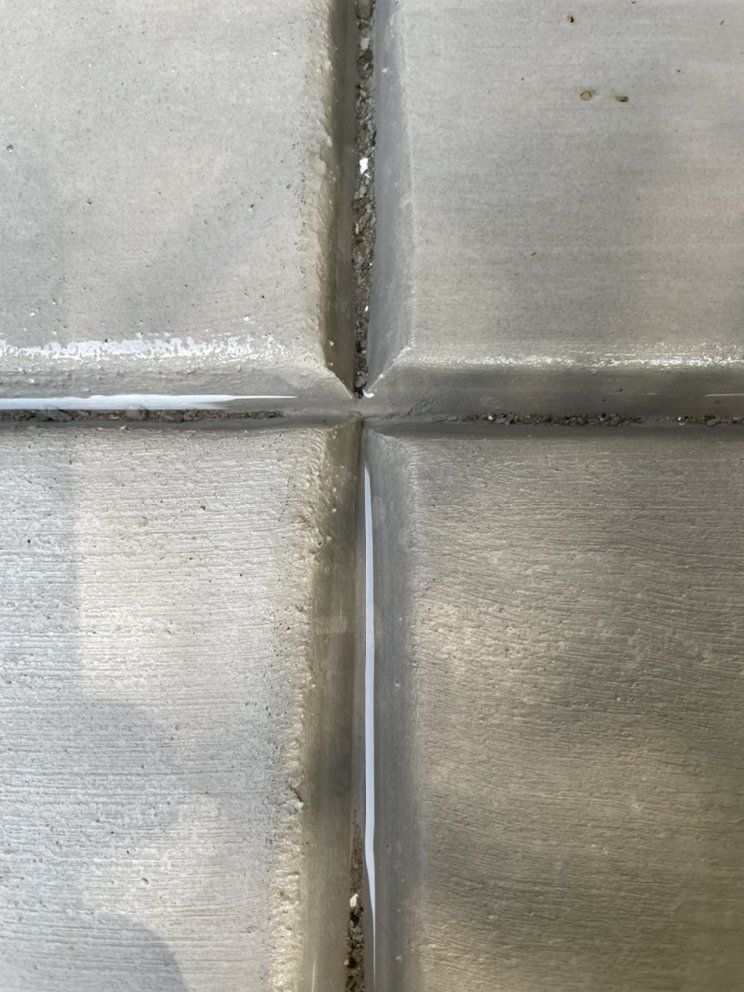 Close-up of a metallic four-panel cross seam with brushed silver texture and wear marks
