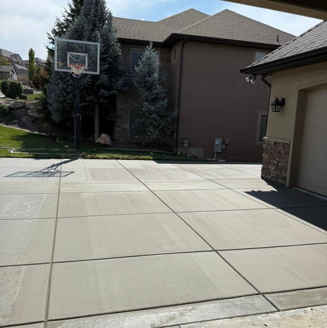 Empty residential driveway with a basketball hoop and suburban homes in bright sunlight