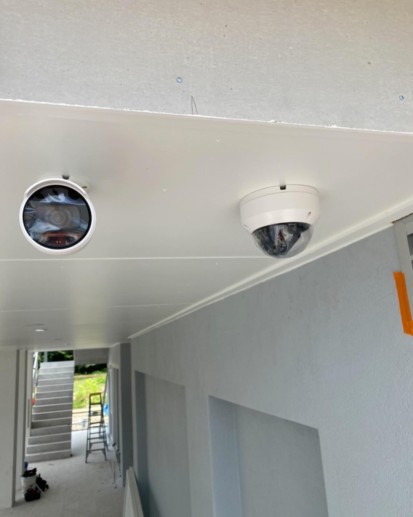 Two Security Cameras Are Mounted on the Ceiling of a Hallway — DGC Tech Solutions In Port Douglas, QLD