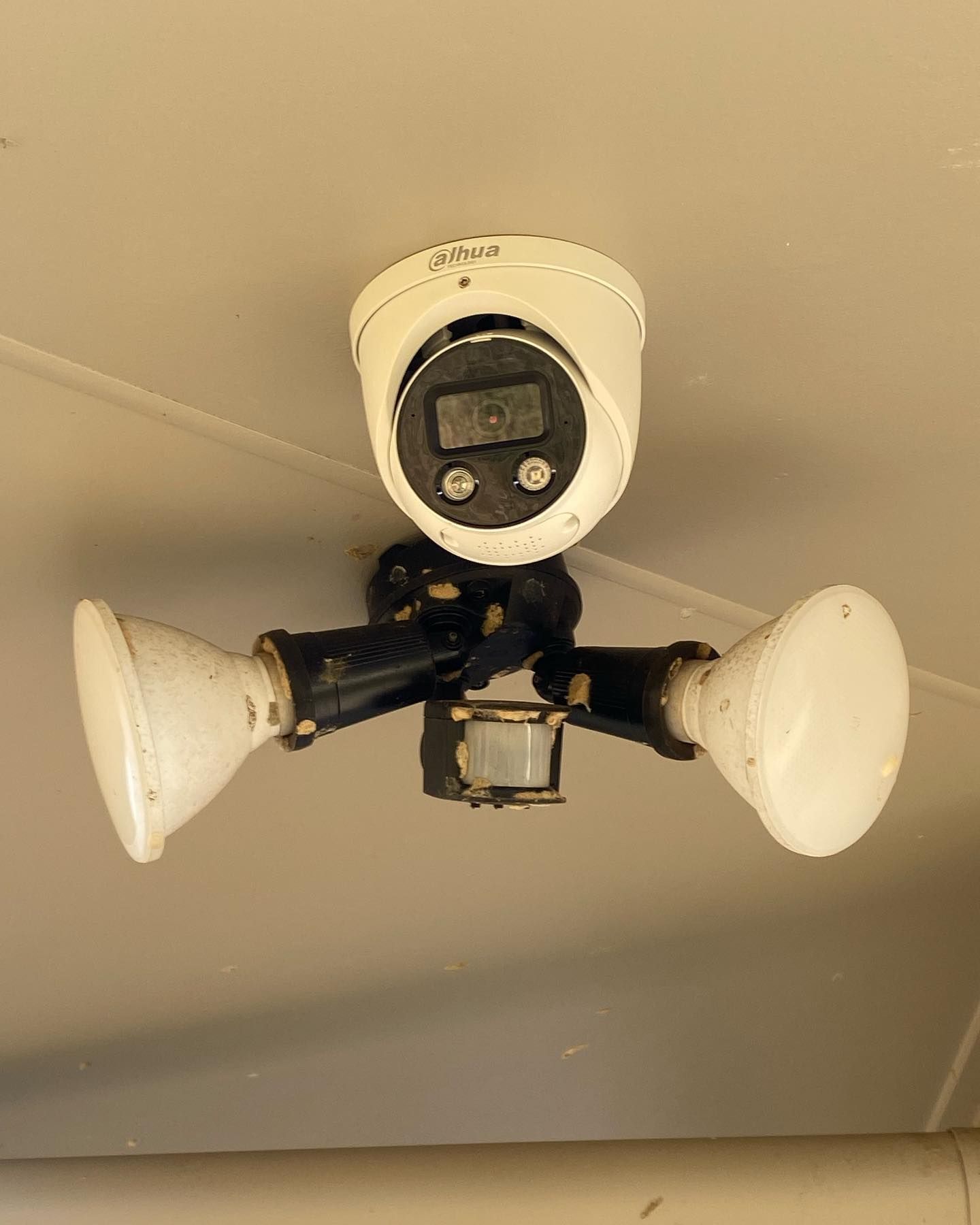 A Security Camera Hanging From the Ceiling With Two Lights Attached to It — DGC Tech Solutions In Atherton, QLD