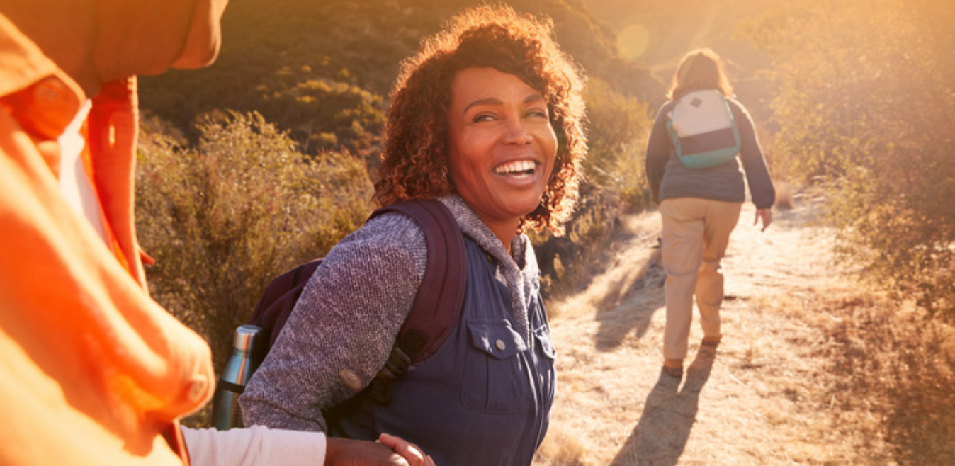 A happy female is hiking with her two friends