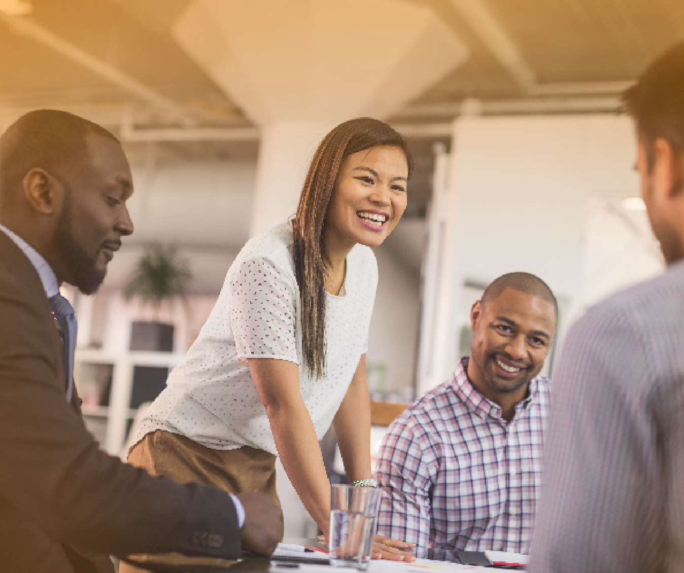 A group of people are sitting around a table having a meeting.