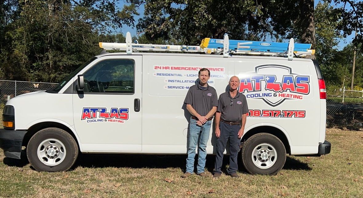 Two men standing in front of a white work van with