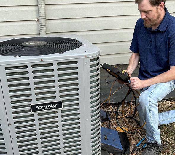 Man inspecting an Ameristar air conditioner unit outdoors, holding tools.